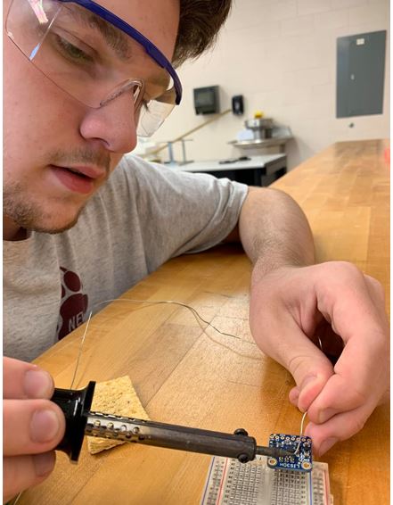 Brett Volker works on circuitry in preparation for the Space Balloon payload project.
