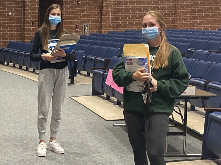 Spring-Ford students Nadine Reid (left) and senior Noelle Reid pick up books on Sept. 16 in the high school auditorium. Students have had to adjust to remote learning this semester due to Covid-19 restrictions. 