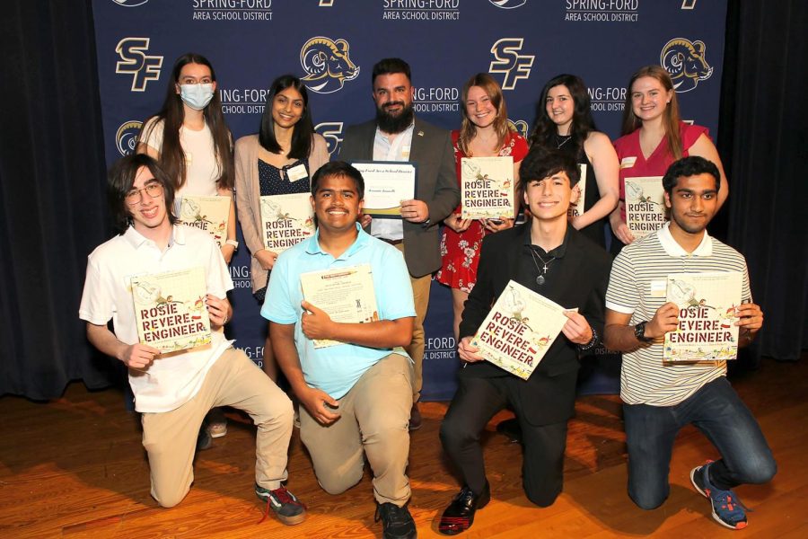 Computer Science teacher Jeramie Iannelli (center) takes a photo with students who nominated him for an Impact Award. . 