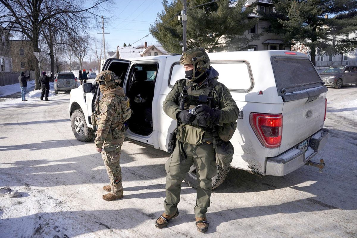 Federal immigration agents stand next to a vehicle as they conduct immigration enforcement tasks in south Minneapolis on Jan. 23. 